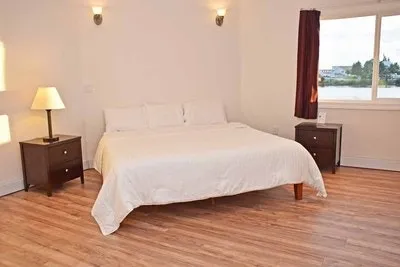 A large bed in a bedroom with wooden floors.
